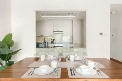 a dining room with a table with plates and silverware at Dubai 1BR City Views, Near Downtown Dining, Culture & Attractions in Dubai