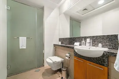 a bathroom with a toilet and a sink and a shower at Dubai 1BR City Views, Near Downtown Dining, Culture & Attractions in Dubai