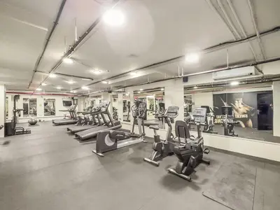 a gym with rows of treadmills and cardio machines at Dubai 1BR City Views, Near Downtown Dining, Culture & Attractions in Dubai