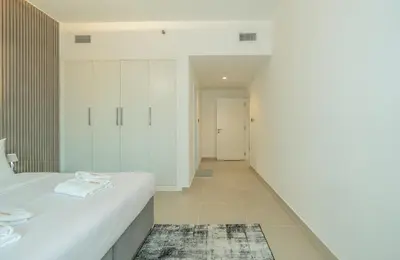 a bedroom with a white bed and a hallway at Zapbed House-Stylish 2 BR in May Residence Block 1 -JVC in Dubai