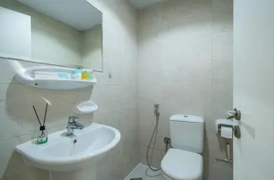a white bathroom with a sink and a toilet at Zapbed House-Stylish 2 BR in May Residence Block 1 -JVC in Dubai