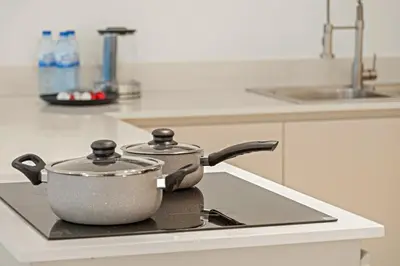 a pot sitting on top of a stove in a kitchen at 2BR Dubai City Skyline View Near Marina Walk Dining Shops & JBR in Dubai