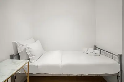a bed with white sheets and pillows on it at 2BR Dubai City Skyline View Near Marina Walk Dining Shops & JBR in Dubai
