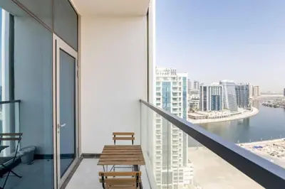 a balcony with a wooden bench and a view of the city at Business Bay, Compact, Modern Studio Dubai in Dubai