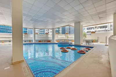 a large swimming pool with red lifesavers in a building at Waves - Gold Opulence 1 BR in Marina in Dubai