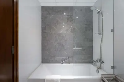 a bathroom with a bath tub with a shower at 2BR Waterfront Apartment Nr Downtown in Dubai