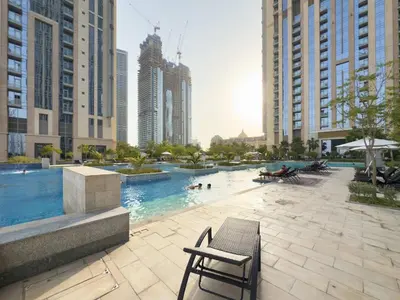 a swimming pool in a city with tall buildings at 2BR Waterfront Apartment Nr Downtown in Dubai