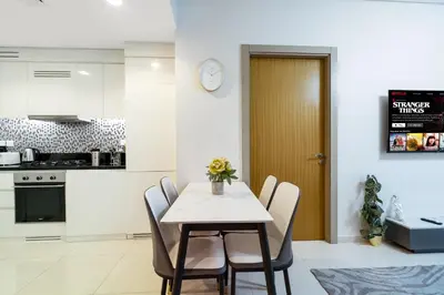 a kitchen and dining room with a table and chairs at Cozy 2BR Pool & City Views in Dubai