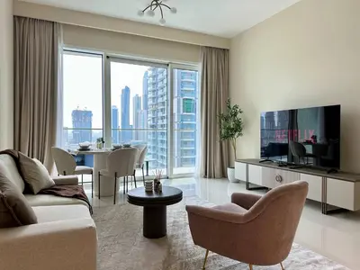 a living room with a couch and a tv at Modern & Cozy 1BR with Great Amenities, Grand Bleu in Dubai