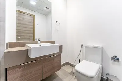 a bathroom with a white sink and a toilet at HAVN - High Floor Studio in Bloom Towers, JVC in Dubai
