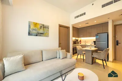 a living room with a couch and a kitchen at Peaceful 2BR with Community Views by BMS in Dubai