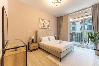 a bedroom with a bed and a large window at HAVN - 1 Spacious Bedroom in Belgravia 1, JVC in Dubai