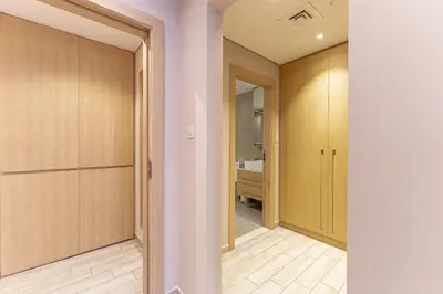 a hallway with wooden doors and a sink in a bathroom at HAVN - 1 Spacious Bedroom in Belgravia 1, JVC in Dubai