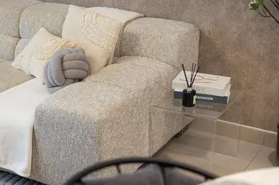 a couch sitting in a living room with a glass table at Luxury apartment with Iconic Landmark View, pool, gym, free parking in Dubai