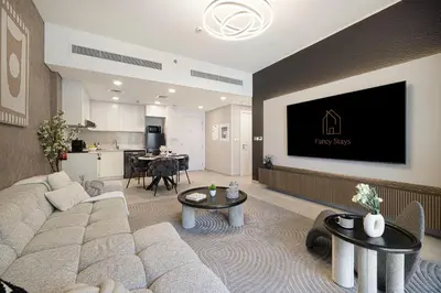 a living room with a couch and a flat screen tv at Luxury apartment with Iconic Landmark View, pool, gym, free parking in Dubai