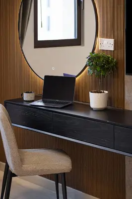 a desk with a laptop and a chair and a mirror at Luxury apartment with Iconic Landmark View, pool, gym, free parking in Dubai