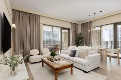 a living room with white furniture and a table at Maison Privee - Creekside Elegance with Canal Vws at Creek Beach in Dubai
