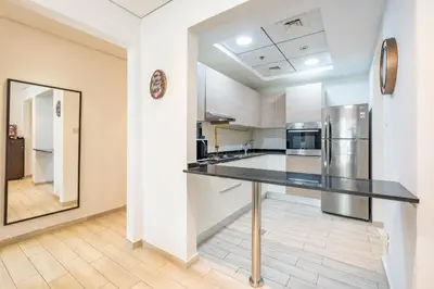 a kitchen with a black counter top and a refrigerator at Urban Comfort 1Bedroom with Pool View in Oxford in Dubai