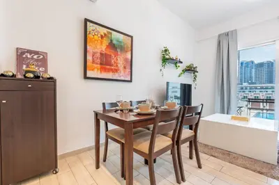 a dining room with a table and chairs and a bath tub at Urban Comfort 1Bedroom with Pool View in Oxford in Dubai