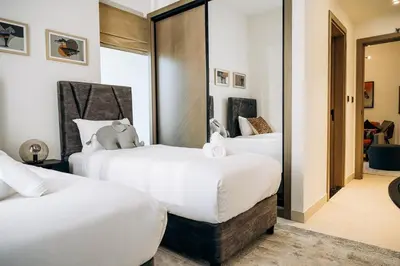 two beds in a hotel room with white sheets at Amazing brand new 2BR - Business Bay-Binghatti in Dubai