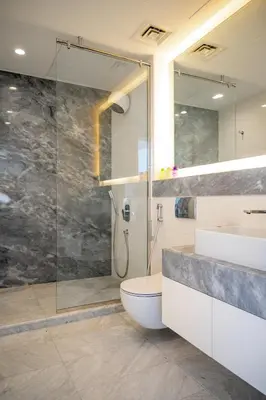 a bathroom with a shower and a toilet and a sink at Luxurious Lake View 1BR - Business Bay - Pool - Gym in Dubai
