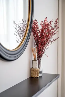 a mirror on a table with a vase with flowers at Luxurious Lake View 1BR - Business Bay - Pool - Gym in Dubai