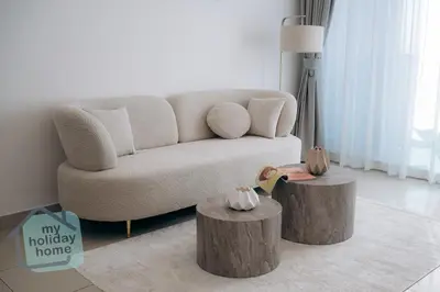 a living room with a couch and two stump tables at Beautiful 1BR-Fully Furnished- Balcony-Pool & Gym in Dubai