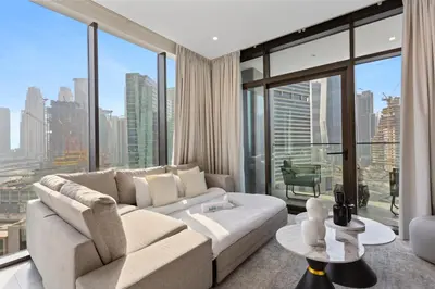 a living room with a white couch and large windows at Bright 1 Bedroom with Burj Khalifa view in Peninsula in Dubai