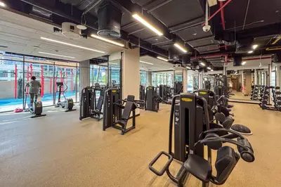 a gym with rows of treadmills and machines at Bright 1 Bedroom with Burj Khalifa view in Peninsula in Dubai