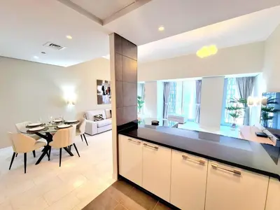 a kitchen and dining room with a table and a dining room at Luxury 2BR in Cayan Tower with Stunning Views in Dubai