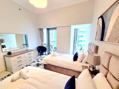 a bedroom with two beds and a mirror at Luxury 2BR in Cayan Tower with Stunning Views in Dubai
