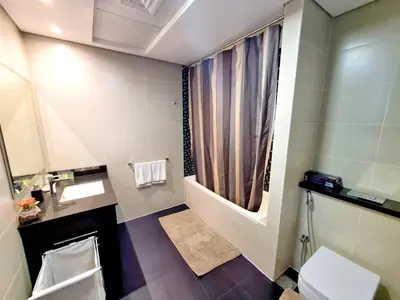 a bathroom with a sink and a toilet and a window at Luxury 2BR in Cayan Tower with Stunning Views in Dubai