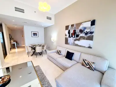 a living room with a couch and a table at Luxury 2BR in Cayan Tower with Stunning Views in Dubai