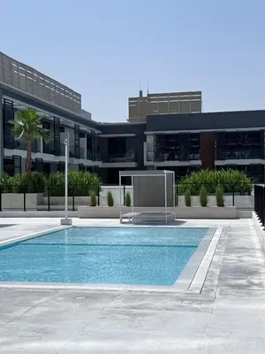 a building with a swimming pool in front of a building at Stunning 1BR in Binghatti Corner, JVC in Dubai