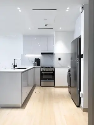 a kitchen with white cabinets and stainless steel appliances at Stunning 1BR in Binghatti Corner, JVC in Dubai