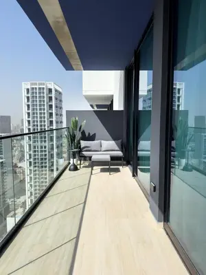 a balcony with a couch and views of the city at Stunning 1BR in Binghatti Corner, JVC in Dubai