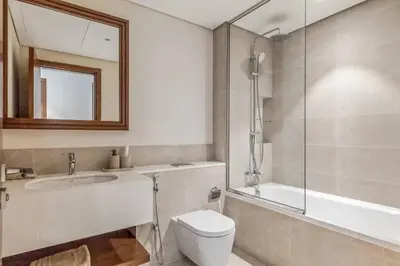 a bathroom with a toilet and a sink and a shower at Luxury & Bright 1BR Apartment | Panoramic Sea View in Dubai
