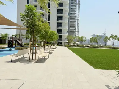 a row of white chairs sitting next to a park at Luxury & Bright 1BR Apartment | Panoramic Sea View in Dubai