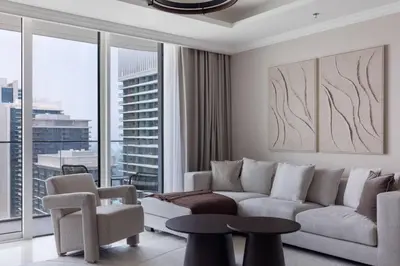 a living room with a couch and a large window at Luxury & Bright 1BR Apartment | Panoramic Sea View in Dubai