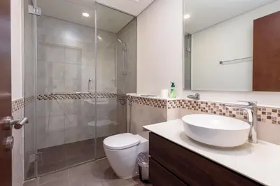 a bathroom with a shower and a sink and a toilet at Tropical Nest in Dubai