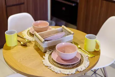 a wooden table with three cups and plates on it at Tropical Nest in Dubai