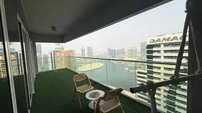 a balcony with two chairs and a view of the city at Tropical Nest in Dubai