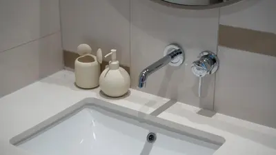 a bathroom counter with a sink and a faucet at Most Luxurious 2BR Apt Beach Access & Palm View in Dubai