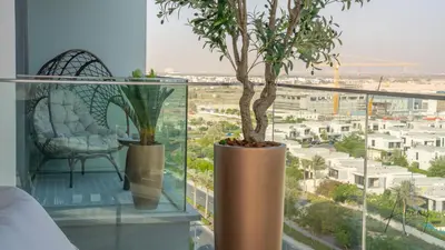 a room with a tree and a chair and a window at GroveLuxurious 1BR BEST communityArt & Design in Dubai