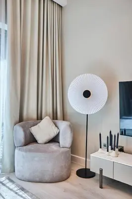 a living room with a chair and a lamp at Sky-High Luxury 1BR in 27th Floor MBL Residence in Dubai