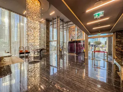 a lobby with a large window and a building at Sky-High Luxury 1BR in 27th Floor MBL Residence in Dubai