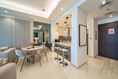 a living room with a table and chairs and a kitchen at Luxe Haven 1BR8min drive DubaiMall & BurjKhalifa in Dubai