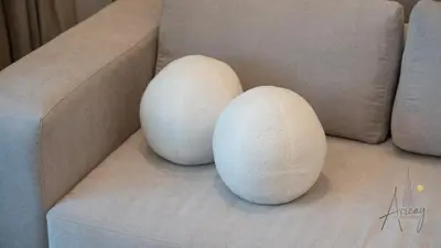 two white spheres sitting on a couch at Luxe Haven 1BR8min drive DubaiMall & BurjKhalifa in Dubai