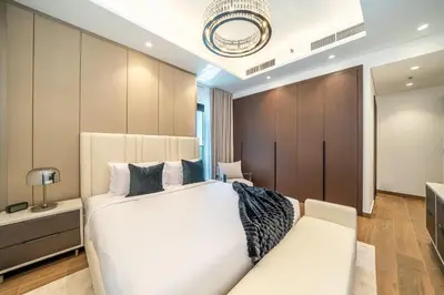 a bedroom with a large white bed and a couch at Sky-High 2BR Escape Stylish Stay Near Dubai Mall in Dubai