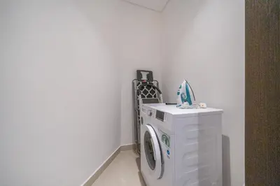 a washing machine in a corner of a room at Sky-High 2BR Escape Stylish Stay Near Dubai Mall in Dubai